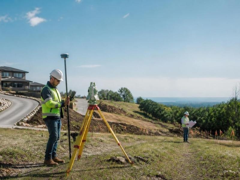 Property surveyor documenting land boundaries and site features for development planning